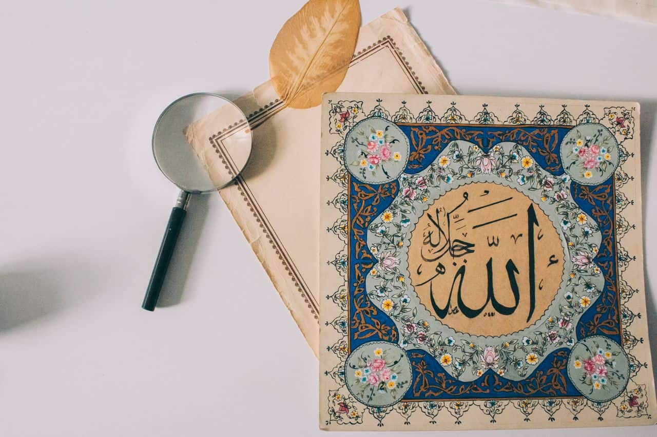 services-04 Elegant Arabic calligraphy with colorful floral motifs and magnifying glass on pale background.