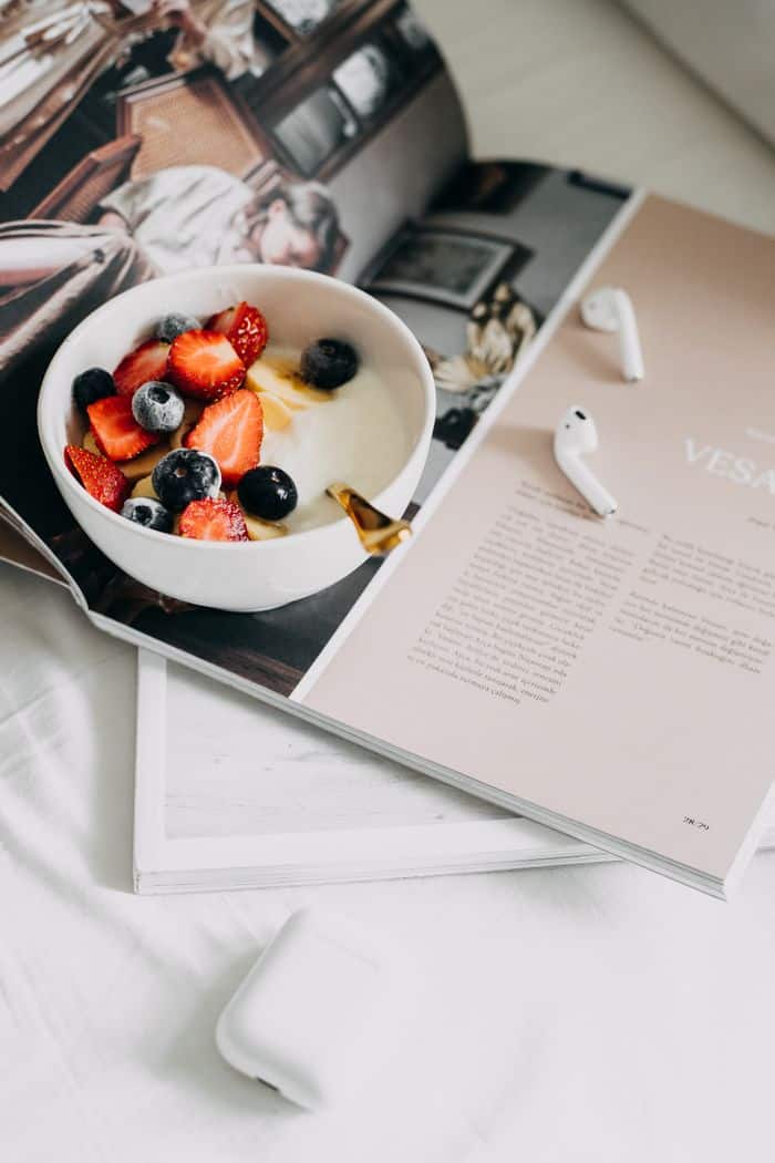 Fresh berries and yogurt bowl on a magazine, a perfect healthy breakfast.