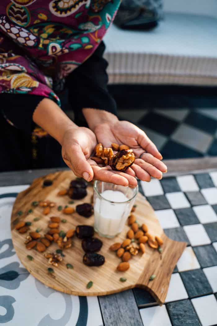A hands-on arrangement of nuts and milk, promoting healthy snacking options.